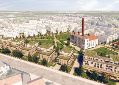 Eine moderne Wohnsiedlung mit grünen Dächern, klassizistischen Fassaden und einem charakteristischen roten Backstein-Industrieschornstein.