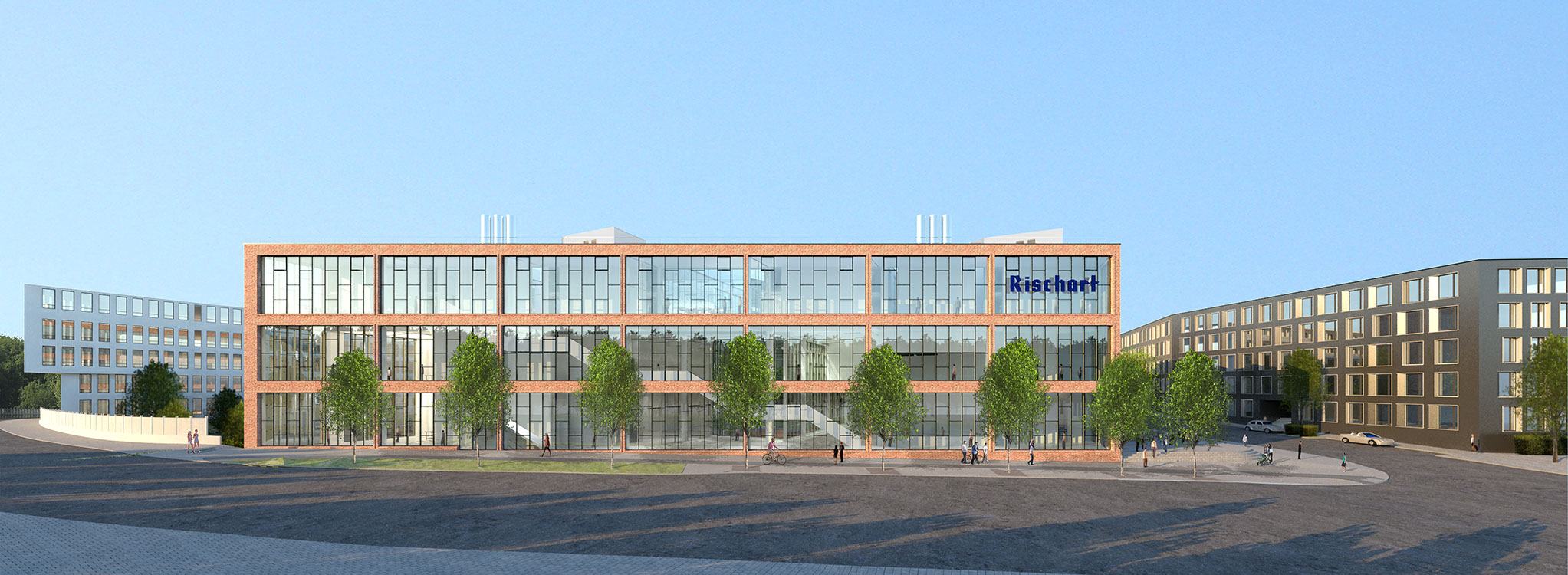 Das moderne Rischart-Gebäude mit roter Backsteinfassade und großflächigen Glasfenstern prägt einen urbanen Platz neben zeitgenössischen Wohnbauten.
